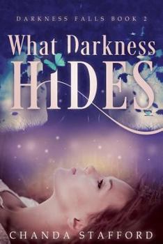 Paperback What Darkness Hides Book