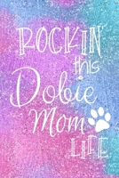 Rockin This Dobie Mom Life: Dobie Dog Notebook Journal for Dog Moms with Cute Dog Paw Print Pages Great Notepad for Shopping Lists, Daily Diary, To Do List, Dog Mom Gifts or Present for Dog Lovers 1697469922 Book Cover